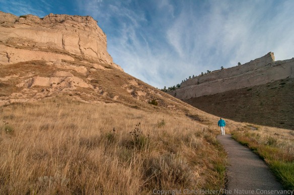 A hiker enjoys the paved trail and gorgeous weather at Scotts Bluff National Monument.